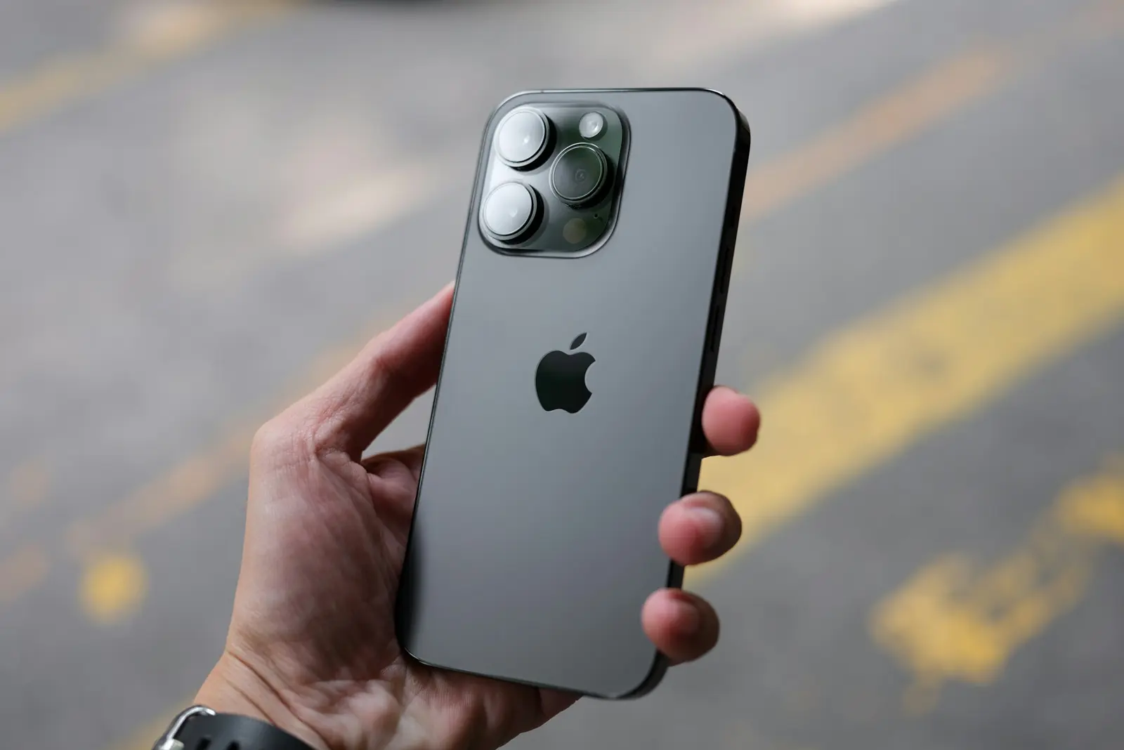 יד אוחזת ב-iPhone 14 Pro שחור עם המצלמות האחוריות גלויות.